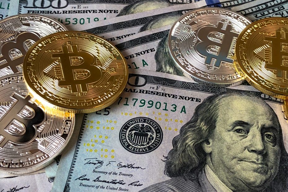 Monedas de Bitcoin, y billetes de dólar estadounidense